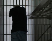 A person leaning agains prison railings