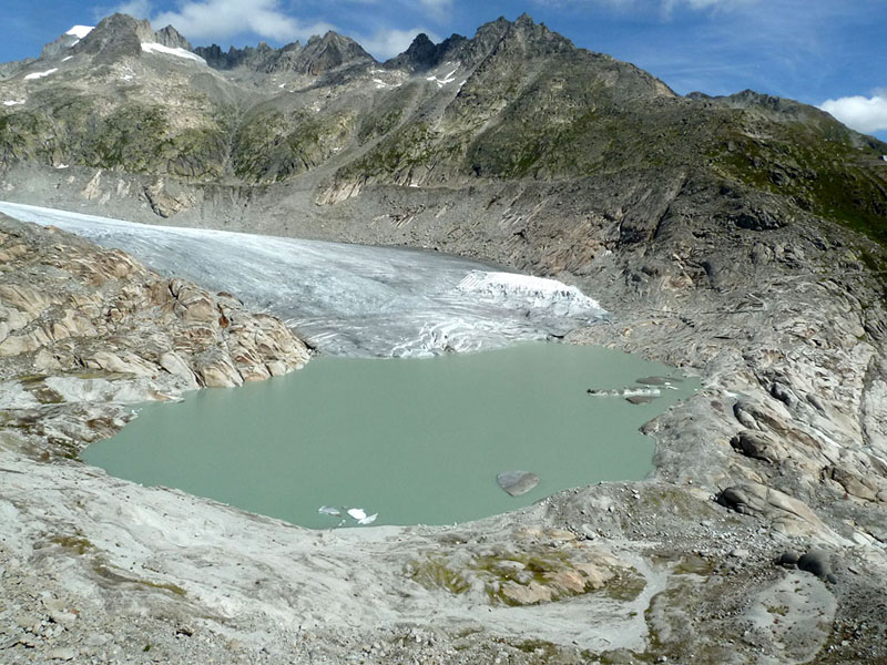 As glaciers recede, many lakes have formed in the high mountains of the world such as at Rhone glacier, Swiss Alps (note at the right margin of the glacier extensive coverage of glacier by geotextiles to 'save' the local ice cave for tourists)